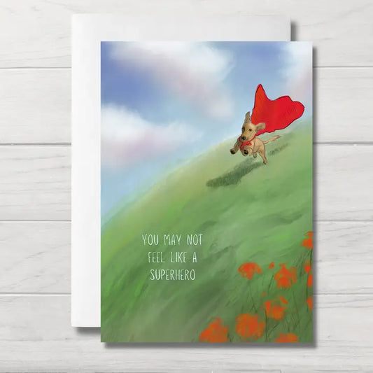 Illustrated cute dachshund dog wearing a red cape running down a big hill. Text reads: you may not feel like a superhero